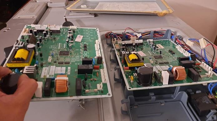 Kỹ thuật viên đang kiểm tra và sửa board mạch tủ lạnh Hitachi bằng máy đo điện